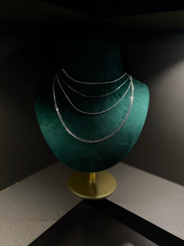 Layered Silver Chain Set on a green display bust